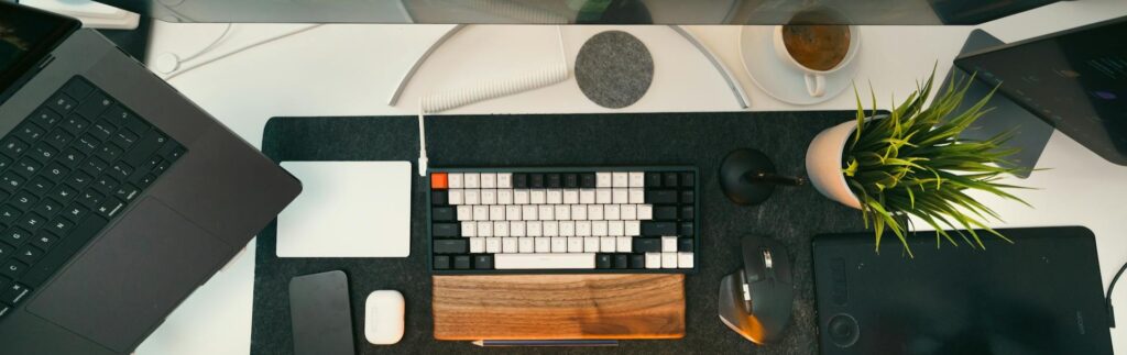 Gestapelte Aktenordner mit Dokumenten Arbeitsplatz in einer Anwaltskanzlei mit Laptop, externem Bildschirm, Tastatur und Maus – Investitionsfreibetrag clever absetzen mit Steuerberater für Rechtsanwälte