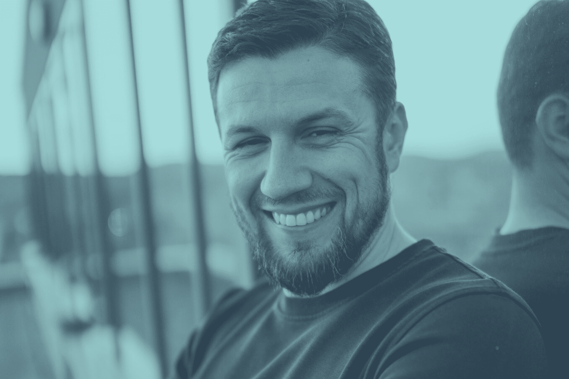 Ein lächelnder Mann mit Bart (Edin, CEO von Tean23 Steuerberatung) in türkisfarbenem Farbfilter. Das Bild wird als Titelbild für den Artikel "So findet jedes Unternehmen den passenden Steuerberater" verwendet.