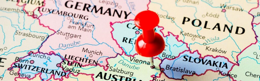 Detailausschnitt einer Landkarte mit roter Stecknadel auf Wien, Österreich – symbolisiert den Standort Österreich und einen neuen Unternehmenssitz.