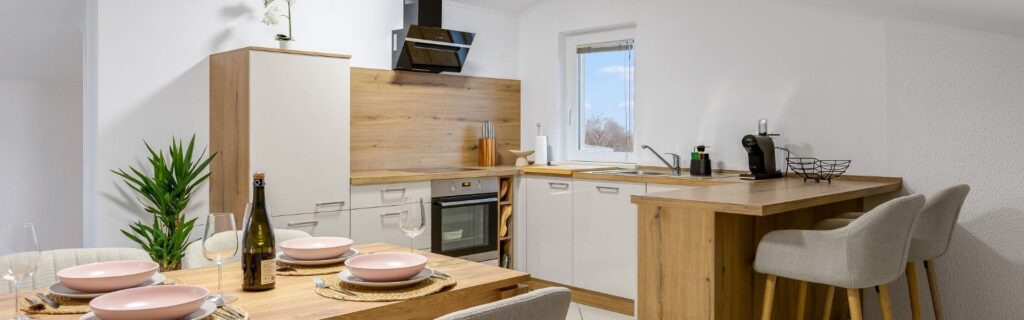 Moderne österreichische Airbnb-Wohnung mit gedecktem Esstisch und heller Küche – Beispiel für gewerbepflichtige Kurzzeitvermietung, Steuerrecht und Anmeldung über Online-Plattformen