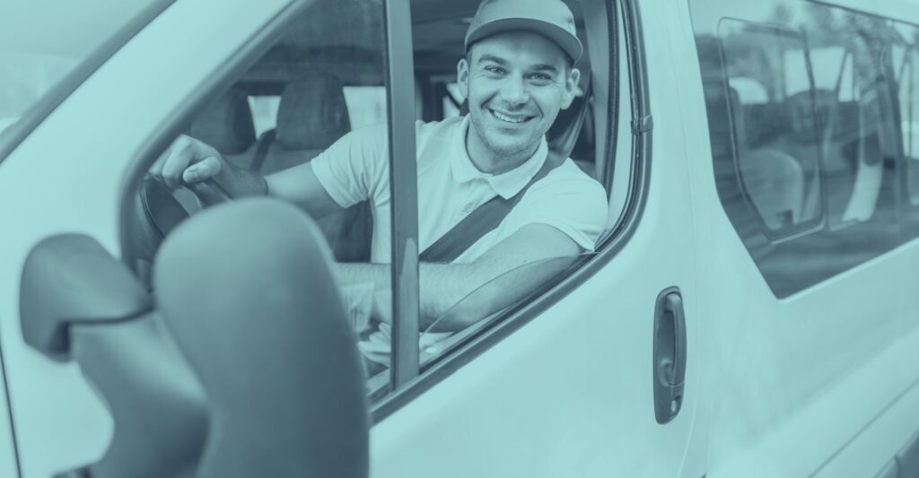 Ein Berufskraftfahrer mit Sicherheitsgurt sitzt hinter dem Steuer eines weißen Firmenbusses und blickt aus dem geöffneten Fenster. Das Bild symbolisiert tägliches Pendeln mit dem Firmenfahrzeug und steht für die praktische Anwendung der Pendlerpauschale und des Pendlereuro ab 2026 in Österreich. Klare Kontraste und Ausrichtung auf den Fahrer gewährleisten eine gute Lesbarkeit für Personen mit Sehbeeinträchtigung; ideal als visuelle Ergänzung für SEO rund um Pendlerpauschale, Pendlereuro, Firmenwagen und Steuervorteil für Arbeitgeber und Arbeitnehmer.