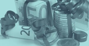 Geldscheine und Euromünzen sind mit Schleifen verziert und als Geschenk dekoriert; repräsentiert steuerfreie Sachgeschenke, Prämien und wichtige Steuertipps zu speziellen Fällen wie Krankenstand, Kündigung oder Altersteilzeit beim Weihnachtsgeld 2025.