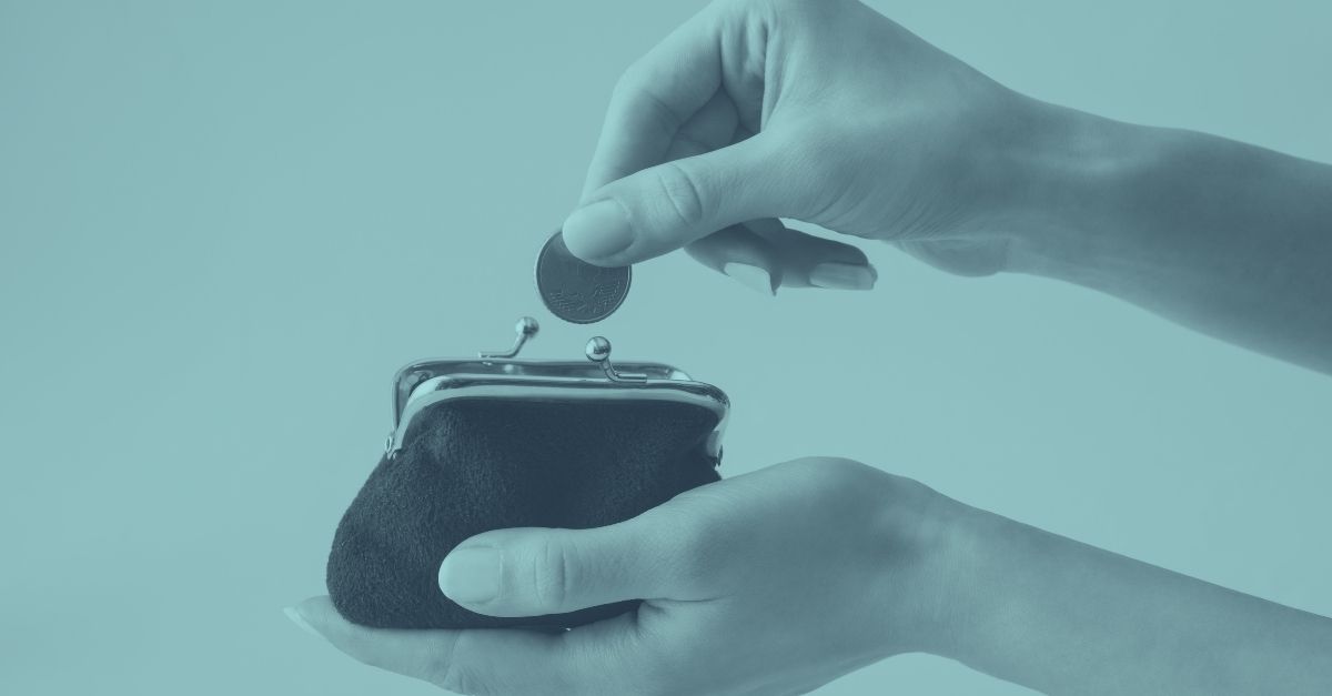 Hand wirft Münze in schwarze Geldbörse. Symbolbild für Basispauschalierung 2026 und Steuerersparnis für Kleinunternehmer und Selbständige in Österreich durch pauschale Gewinnermittlung