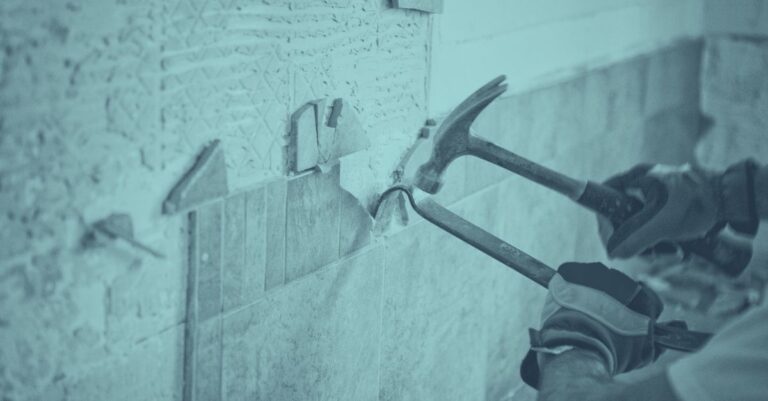 Bauwerkzeuge wie Hämmer und Meißel schlagen auf eine strukturierte Wand während einer Immobiliensanierung – Symbolbild für energetische Gebäudesanierung und steuerliche Abschreibung in Österreich