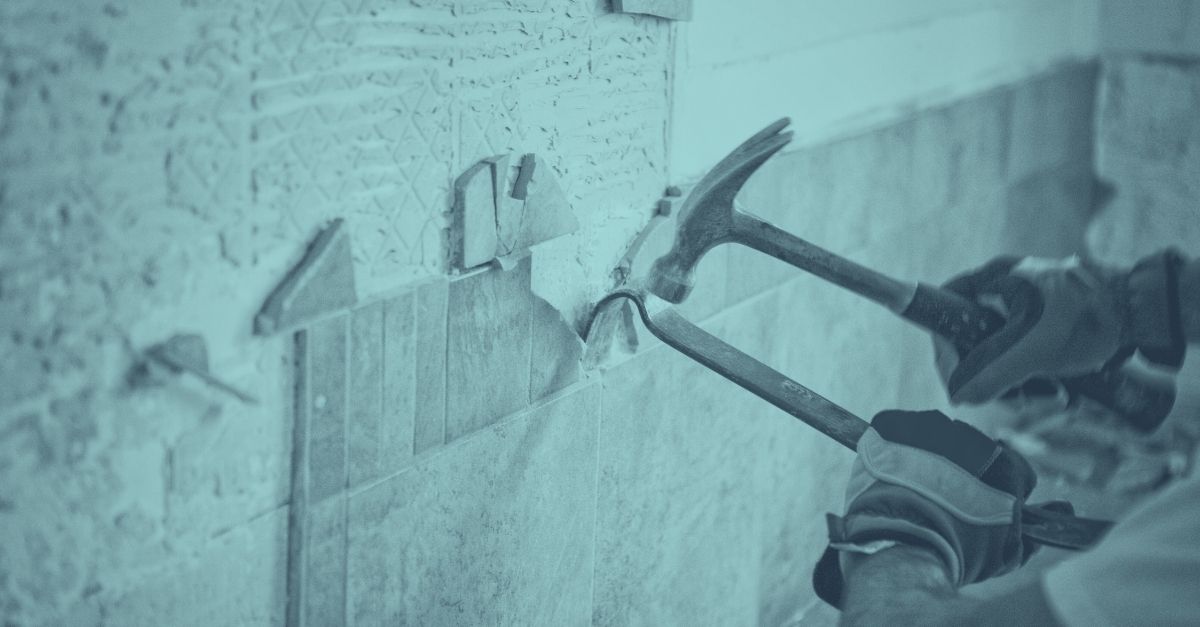 Bauwerkzeuge wie Hämmer und Meißel schlagen auf eine strukturierte Wand während einer Immobiliensanierung – Symbolbild für energetische Gebäudesanierung und steuerliche Abschreibung in Österreich