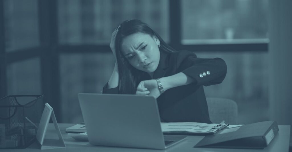 Gestresste Geschäftsfrau am Laptop. Symbolisiert steuerfreie Überstunden in Österreich 2026 werden reduziert, Arbeitgeber müssen Alternativen finden"