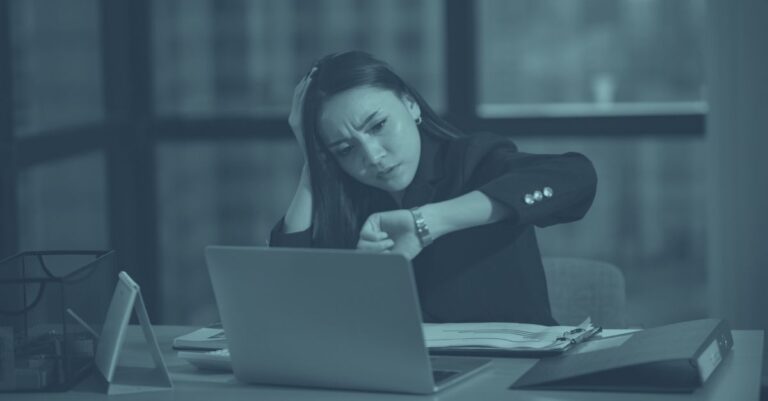 Gestresste Geschäftsfrau am Laptop. Symbolisiert steuerfreie Überstunden in Österreich 2026 werden reduziert, Arbeitgeber müssen Alternativen finden"