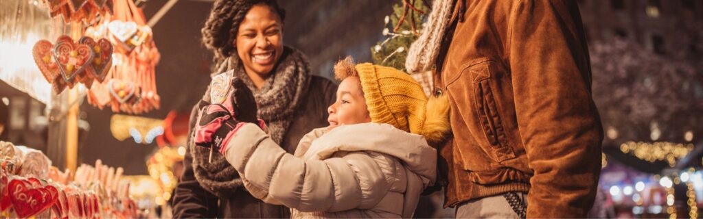 Familie am Weihnachtsmarkt in Österreich – symbolisiert Feiertagsremuneration bleibt mit bis zu 400 Euro monatlich steuerfrei und attraktiv für Arbeitgeber