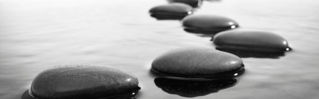 Schwarze Silhouette einer Person, die mit weit ausgebreiteten Armen auf einem Felsen oder erhöhten Punkt steht. Der Hintergrund zeigt einen dramatischen Sonnenuntergang mit rosa-violettem Himmel. Die Körperhaltung drückt Triumph, Freiheit und Erfolg aus. Das Bild symbolisiert den Erfolgsmoment von Immigrant-Gründern, die ihre Ziele erreicht haben – für den Abschnitt über erfolgreiche Branchen für migrantische Unternehmer in Österreich.
