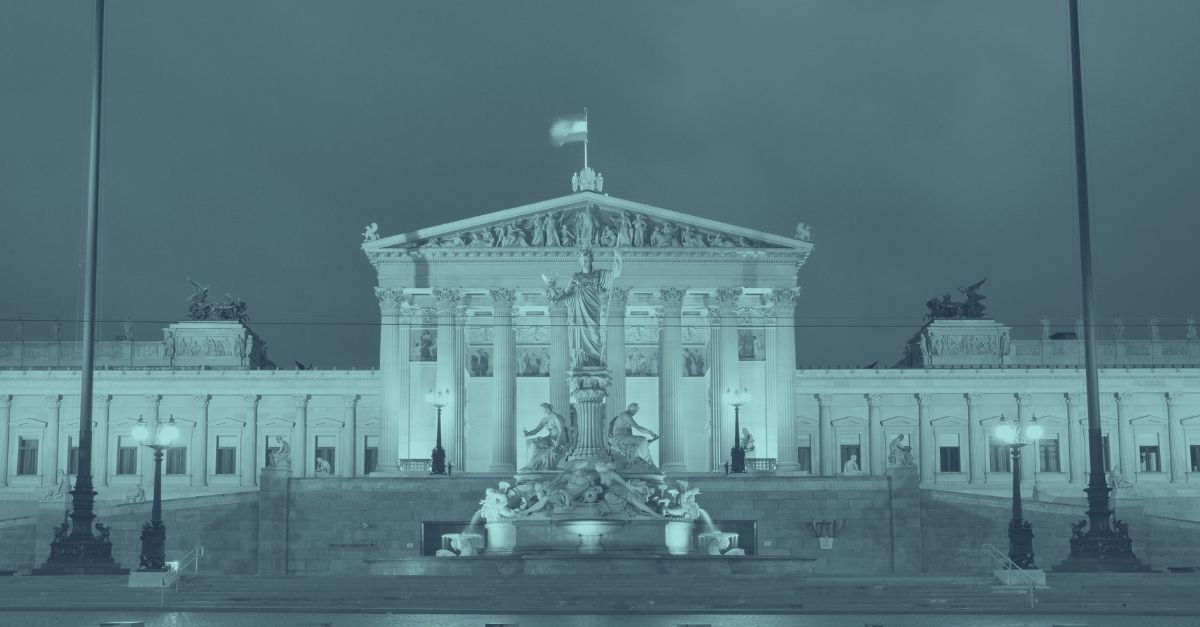 Österreichisches Parlamentsgebäude in Wien bei Nacht beleuchtet in Türkis-Tönen, symbolisiert Wirtschaftslage Österreich 2026 und Rezessionsprognose. Parlamentsfassade mit Athena-Brunnen im Vordergrund repräsentiert politische und wirtschaftliche Stabilität nach zwei Jahren Rezession. Titelbild zum Blog über WIFO Wirtschaftsprognose, BIP-Wachstum, Inflation und Branchenentwicklung für KMU, Bau und Gesundheitssektor.