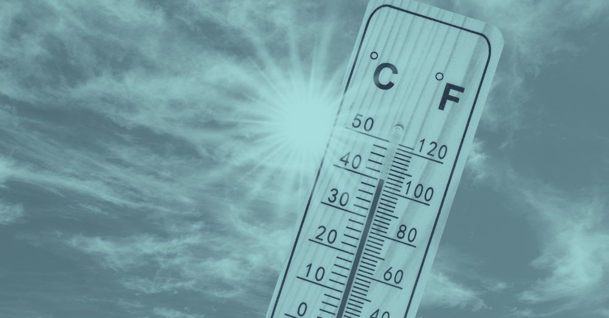 Holzthermometer mit hohen Temperaturen vor sonnigem Himmel – Symbol für Sommerhitze und Hitzeschutz am Arbeitsplatz im Freien gemäß Hitzeschutzverordnung 2026.
