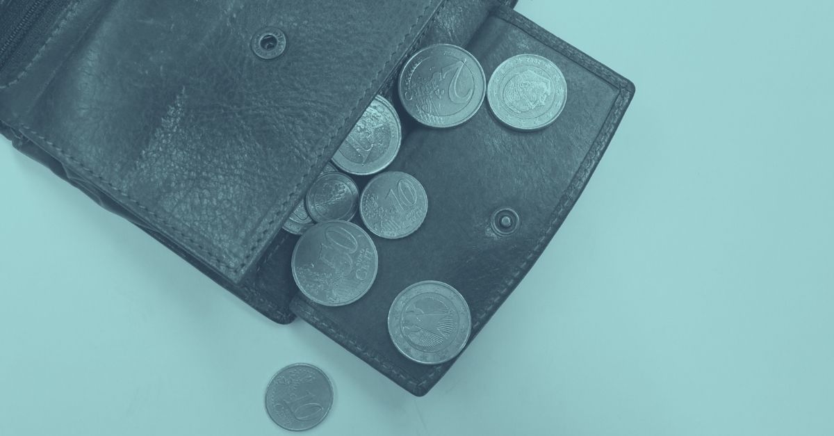 Offene Geldbörse mit mehreren Euro-Münzen, aufgenommen in blauer Tönung – symbolisch für Trinkgeld in Österreich und die neue einheitliche Trinkgeldregelung 2026 für Gastronomie und Hotellerie.