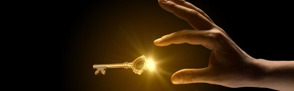 Eine Hand greift nach einem golden leuchtenden Schlüssel vor schwarzem Hintergrund – steht dafür, dass durch kluges Risikomanagement der Schlüssel liegt, Unternehmensrisiken zu kontrollieren und den Betrieb langfristig zu sichern.
