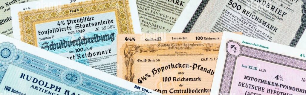 Mehrere übereinanderliegende historische Wertpapiere und Anleihen – Symbolbild für den Gewinnfreibetrag auf Wertpapierinvestitionen