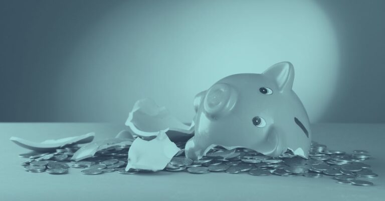 Ein in Stücke zerbrochenes rosa Sparschwein liegt auf einem großen Haufen von Geldmünzen vor einem blaugrauen Hintergrund. Das Bild symbolisiert die finanzielle Belastung für Unternehmen, die mit einer COFAG Rückforderung oder der Rückzahlung von Corona-Förderungen konfrontiert sind.